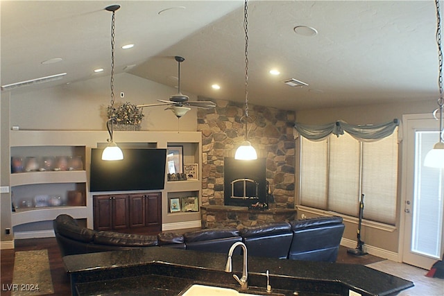 living room featuring lofted ceiling, ceiling fan, a fireplace, wood-type flooring, and sink