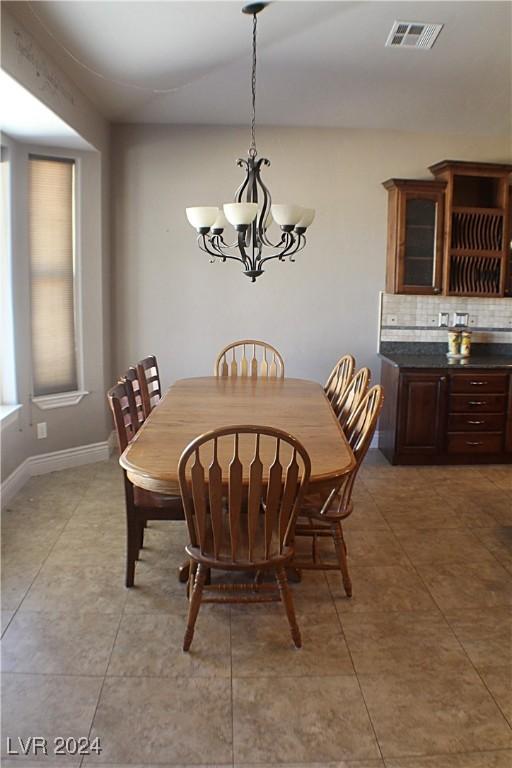 dining room with baseboards, a chandelier, visible vents, and light tile patterned floors