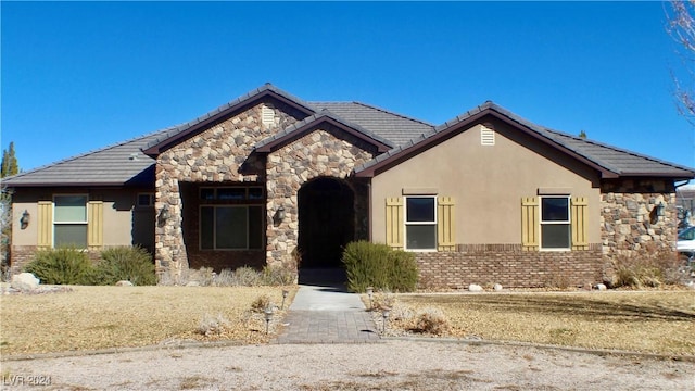view of front of home featuring stone siding and stucco siding