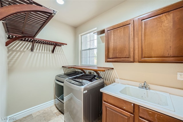 laundry room with cabinets, independent washer and dryer, and sink