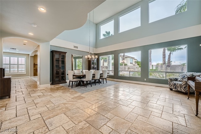 dining area with plenty of natural light, a high ceiling, and a notable chandelier