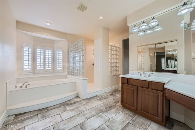 bathroom with vanity and shower with separate bathtub