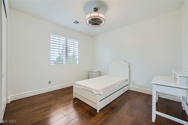 bedroom with dark hardwood / wood-style floors