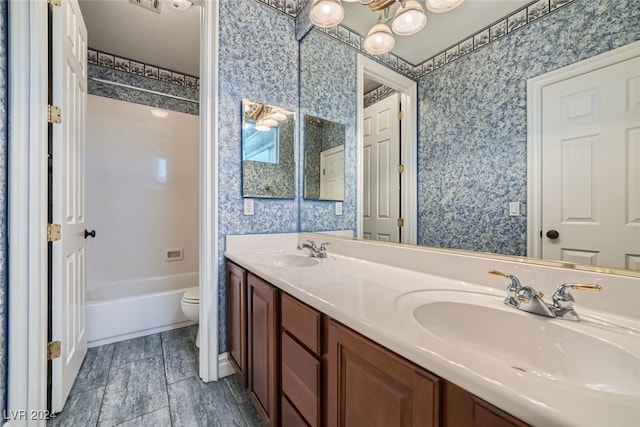 full bathroom featuring washtub / shower combination, vanity, and toilet