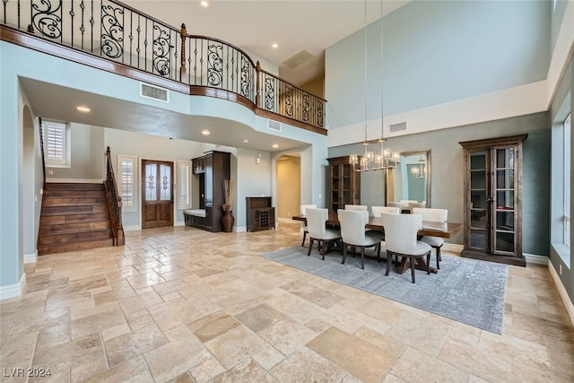 dining room featuring a towering ceiling and a notable chandelier