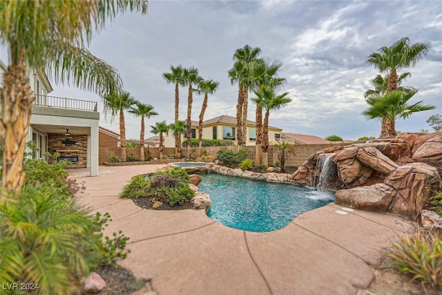 view of swimming pool featuring pool water feature, ceiling fan, and a patio area