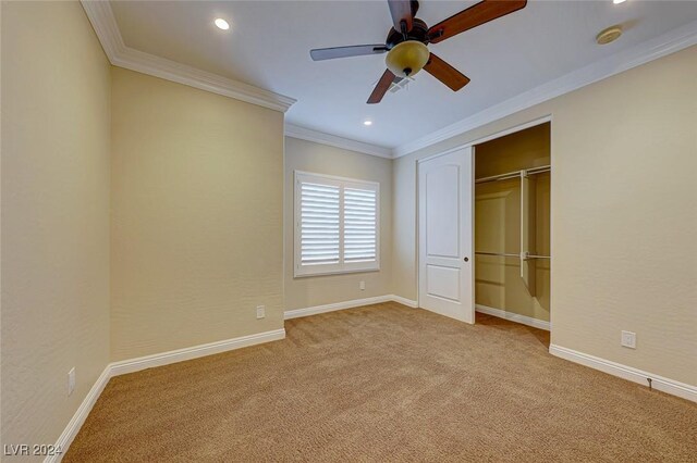 unfurnished bedroom featuring light carpet, a closet, ceiling fan, and crown molding