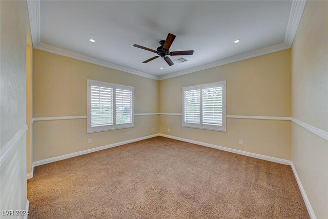 carpeted empty room with crown molding, ceiling fan, and a wealth of natural light