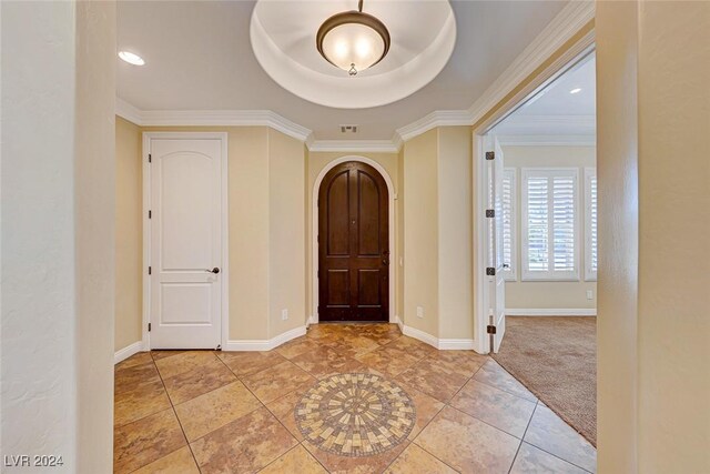 foyer entrance with light tile patterned flooring and a tray ceiling