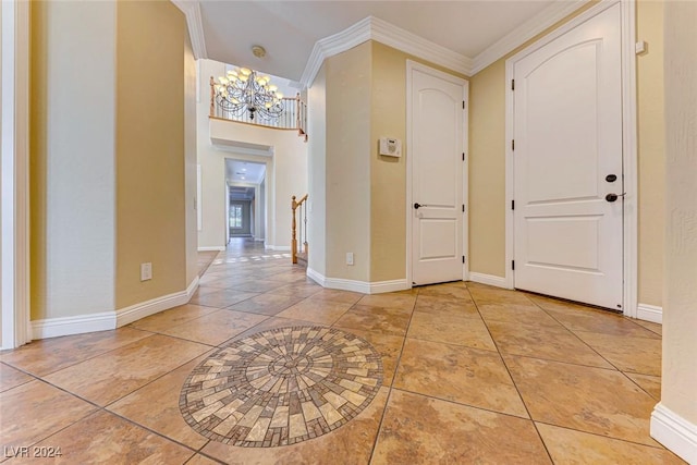 entryway featuring light tile patterned floors, baseboards, crown molding, and an inviting chandelier