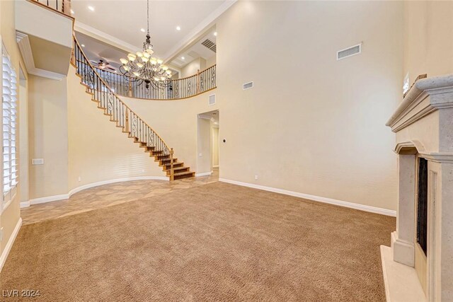 unfurnished living room with a high ceiling, crown molding, a chandelier, and light colored carpet