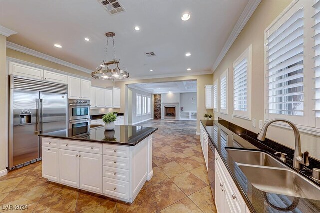 kitchen with white cabinetry, sink, appliances with stainless steel finishes, and a kitchen island