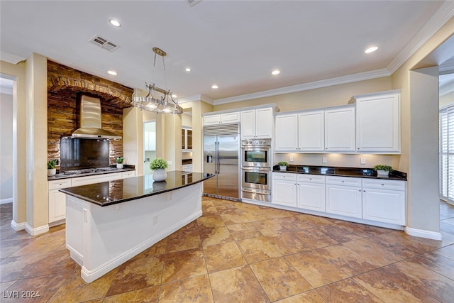 kitchen with white cabinetry, light tile patterned floors, a kitchen island, appliances with stainless steel finishes, and wall chimney exhaust hood