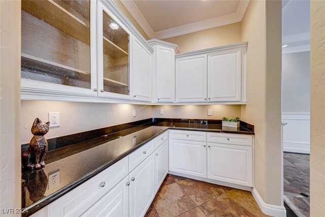 kitchen with light tile patterned flooring, white cabinetry, and crown molding