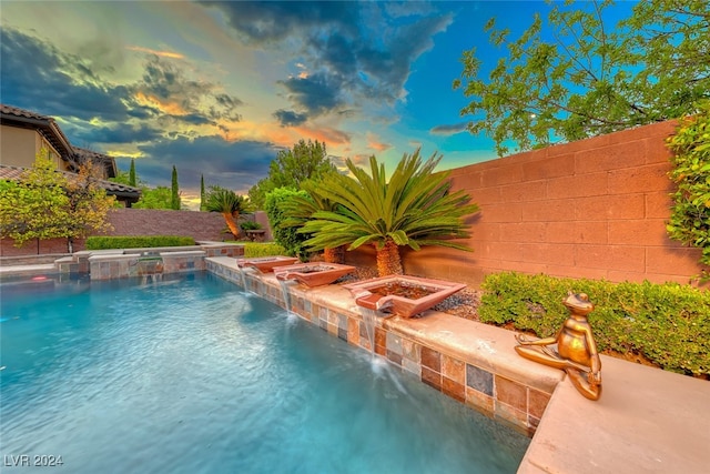 pool at dusk with pool water feature