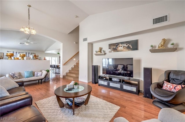 living room with hardwood / wood-style floors, high vaulted ceiling, and a chandelier