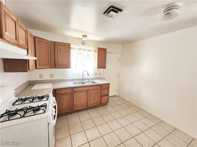 kitchen featuring sink, light tile patterned flooring, and white range with gas cooktop