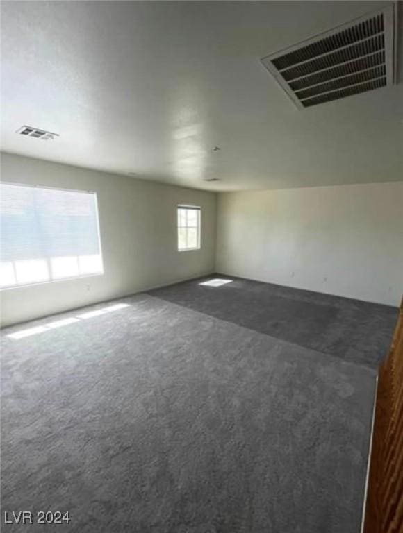 empty room with dark colored carpet