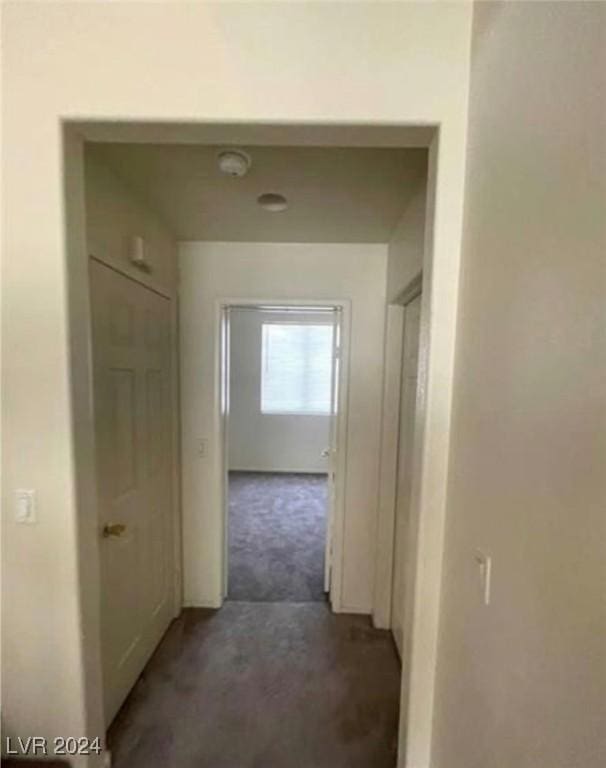 hallway with dark colored carpet