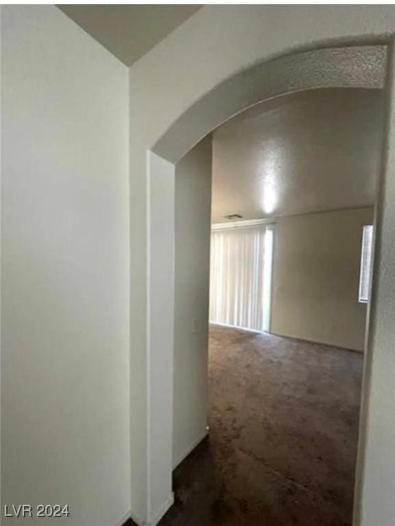 hallway with dark colored carpet