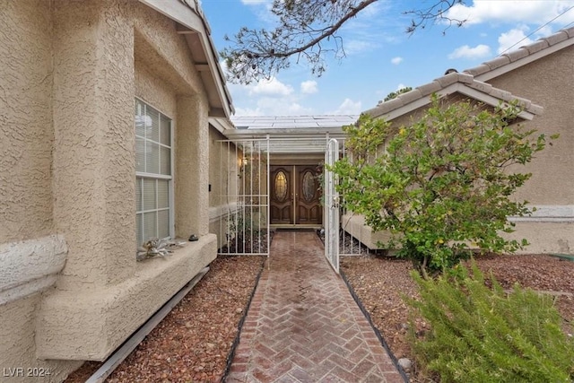 doorway to property with a tile roof and stucco siding