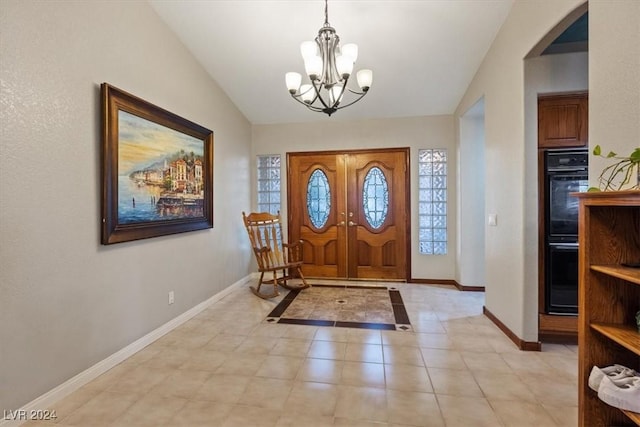 entrance foyer featuring lofted ceiling, light tile patterned flooring, baseboards, and an inviting chandelier