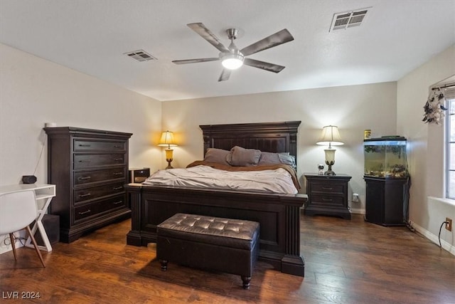 bedroom with dark wood-style floors, ceiling fan, visible vents, and baseboards