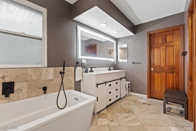 full bath with a freestanding tub, vanity, and baseboards