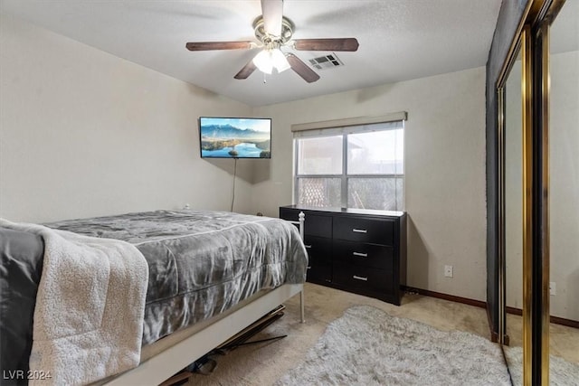 bedroom featuring light carpet, a ceiling fan, visible vents, and baseboards