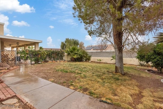 view of yard with a ceiling fan, a fenced backyard, and a patio