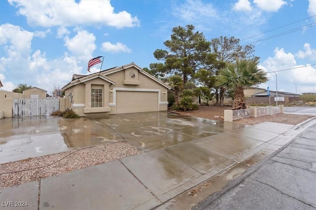 view of front of property with a garage, driveway, fence, and stucco siding