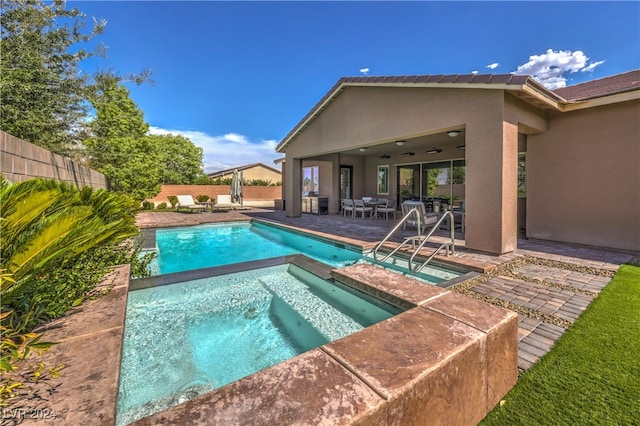 view of pool featuring an in ground hot tub and a patio