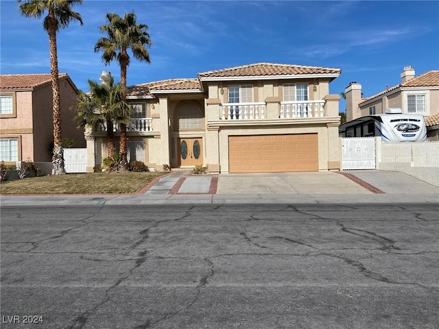 view of front of home with stucco siding, concrete driveway, a balcony, an attached garage, and fence