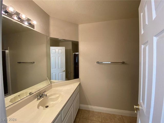 bathroom with baseboards, vanity, and tile patterned flooring