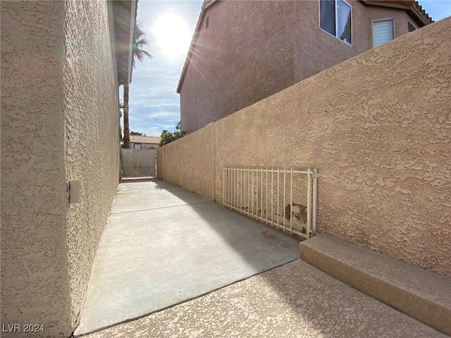 view of property exterior featuring fence, stucco siding, and a patio