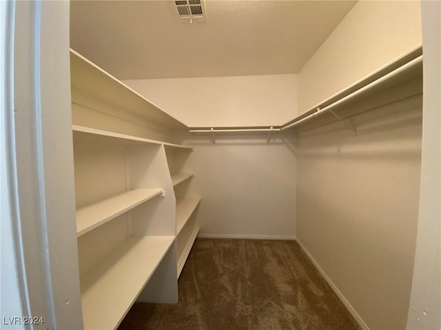 walk in closet featuring visible vents and dark colored carpet