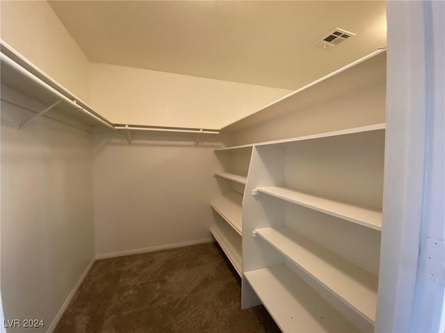 walk in closet with visible vents and dark carpet