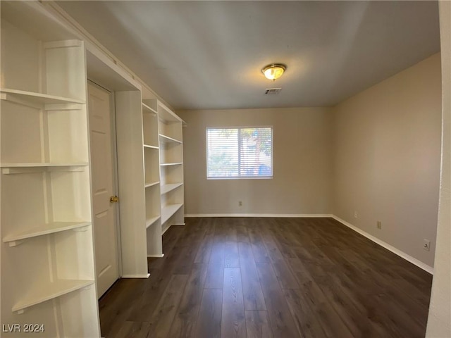 interior space featuring baseboards, visible vents, and dark wood finished floors