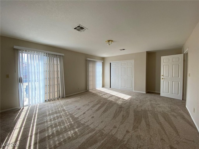 interior space with visible vents, a closet, baseboards, and carpet