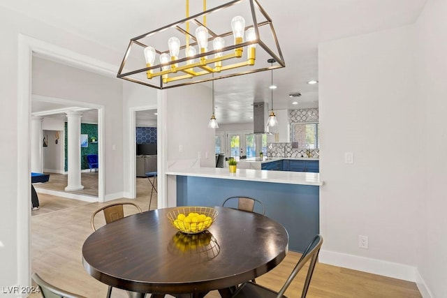 dining space featuring french doors, recessed lighting, ornate columns, light wood-style floors, and baseboards