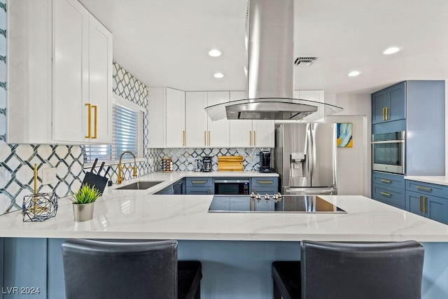 kitchen featuring stainless steel appliances, a sink, island range hood, and light stone countertops