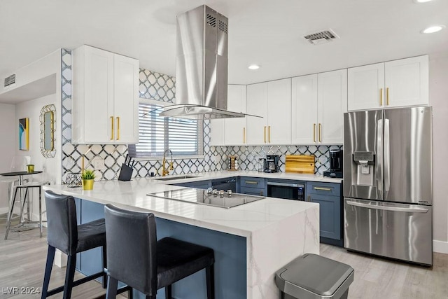 kitchen featuring white cabinets, appliances with stainless steel finishes, island exhaust hood, light countertops, and a sink