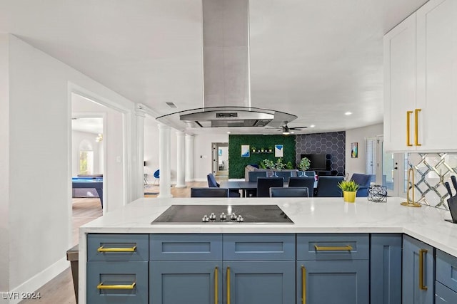 kitchen featuring black electric stovetop, white cabinetry, a ceiling fan, open floor plan, and decorative columns