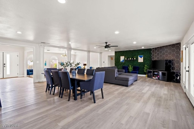 dining space with an accent wall, light wood finished floors, and recessed lighting