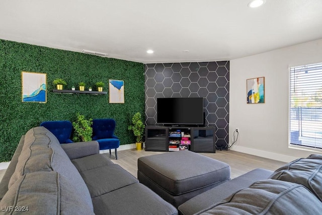 living area with light wood finished floors, recessed lighting, visible vents, an accent wall, and baseboards