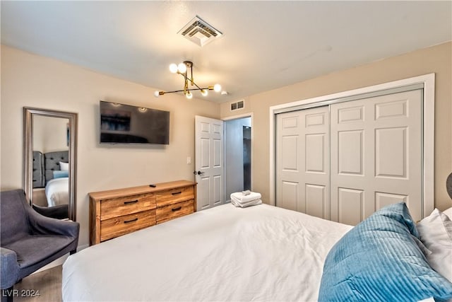 bedroom with a closet, visible vents, and a notable chandelier