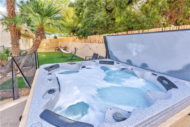 view of storm shelter with a jacuzzi and a fenced backyard