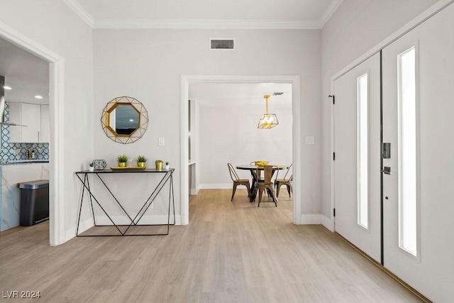 foyer with light wood-style flooring, visible vents, french doors, ornamental molding, and plenty of natural light