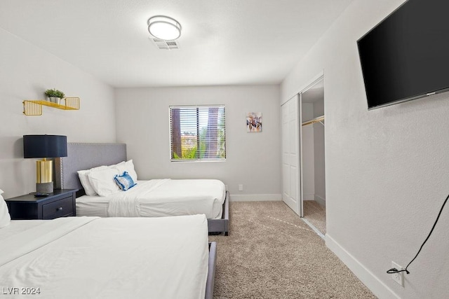 bedroom with baseboards, a closet, visible vents, and light colored carpet