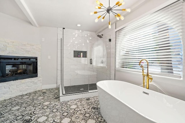 bathroom with a stall shower, an inviting chandelier, tile patterned flooring, a freestanding bath, and a stone fireplace